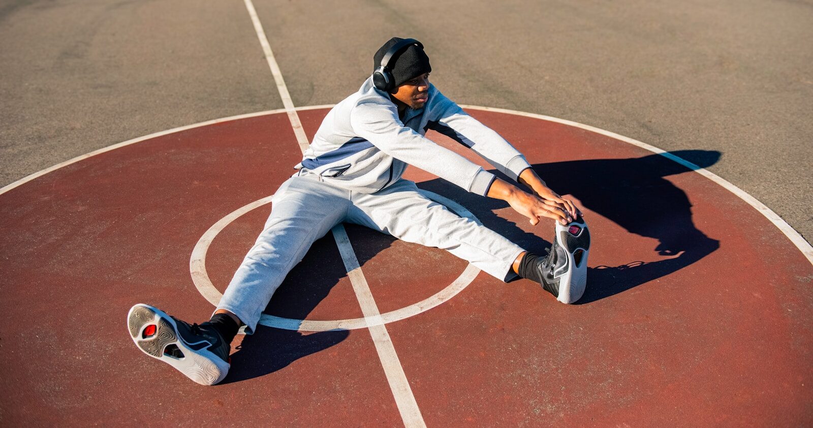 a man sitting on top of a basketball court